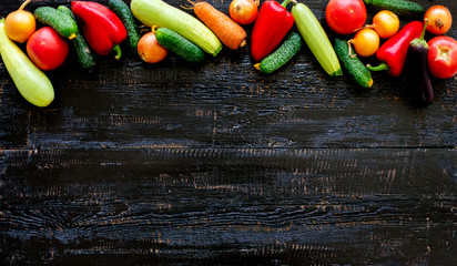 Autumn harvest. Vegetables - tomatoes and cucumbers, carrots and cauliflower, zucchini and eggplant, onions and potatoes on an old wooden background.
