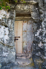 Old and weathered wooden door at the entrance of a cave