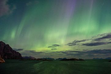 Northern lights dancing above the ocean