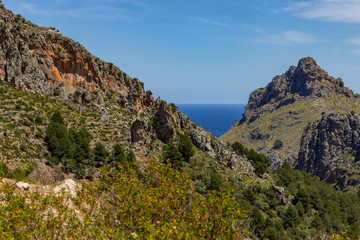 Fototapeta na wymiar Scenic view at landscape of Serra de Tramuntana on island Mallorca, Spain on a sunny day with rocks in front and mediterranean sea in background