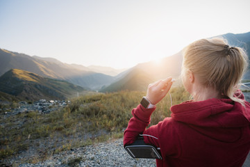 Close up image of woman adjusting headphones before starting jogging.