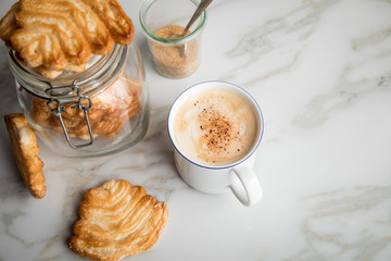 Italienische Blätterteig Fächer Kekse mit Einmachglas und Becher Kaffee auf Marmor Hintergrund