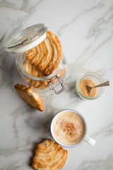 Italienische Blätterteig Fächer Kekse mit Einmachglas und Becher Kaffee auf Marmor Hintergrund