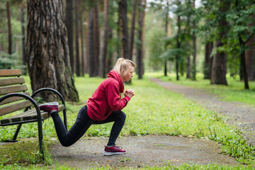 Sporty woman practicing squat exercises in the park.