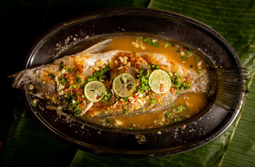 Spicy​ steamed fish on top​ with​ lime.