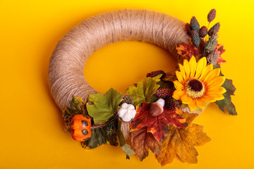 Handmade wreath of small pumpkins and flowers on a vintage door