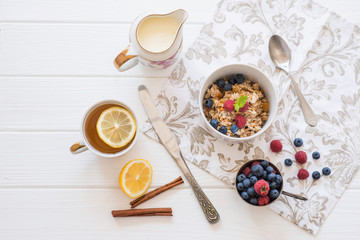 Fototapeta na wymiar breakfast oatmeal with raspberries and blueberries with tea and honey lemon diet slimming healthy food