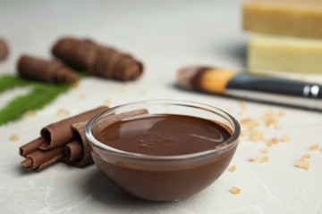 Professional chocolate face mask on light gray marble table, closeup