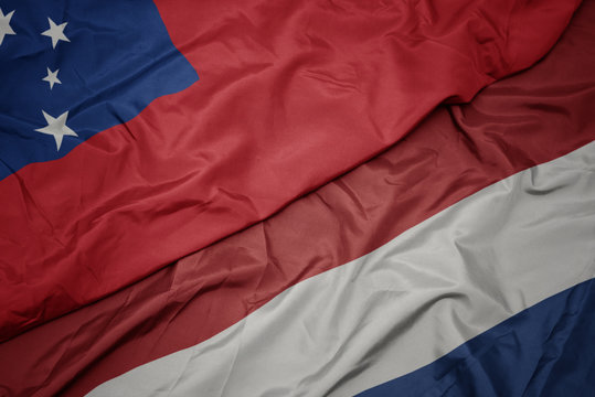 waving colorful flag of netherlands and national flag of Samoa .