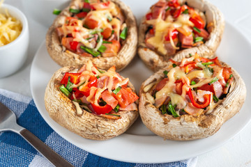 Mushrooms stuffed with bacon, tomato, red pepper, chives and cheese.