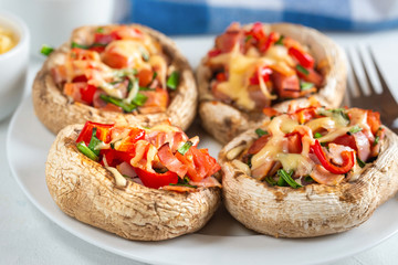 Mushrooms stuffed with bacon, tomato, red pepper, chives and cheese.
