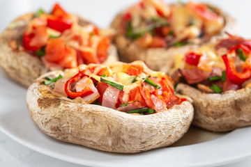 Mushrooms stuffed with bacon, tomato, red pepper, chives and cheese.