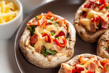 Mushrooms stuffed with bacon, tomato, red pepper, chives and cheese.