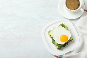 Delicious breakfast with fried egg served on table, flat lay. Space for text