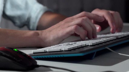 Cropped shot of a man typing on computer keyboard. Hands of unrecognizable man typing on computer keyboard, clicking the mouse. Man working on a computer