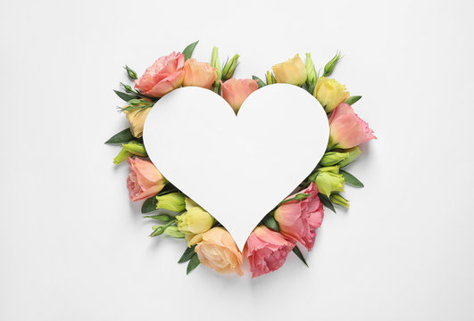 Beautiful Eustoma flowers and card on white background, top view. Space for text