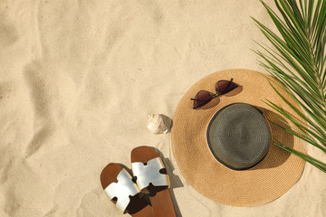 Fototapeta na wymiar Flat lay composition with stylish beach accessories on sand