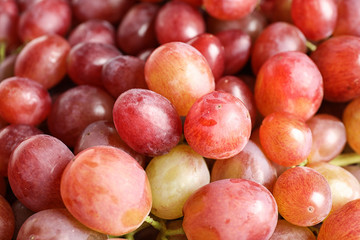 Fresh ripe juicy pink grapes as background, closeup view