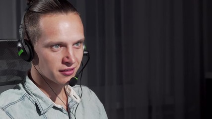 Cropped shot of a handsome young man working at call center on night shift. Sliding shot of a male customer support operator talking with a client using headset. Service concept