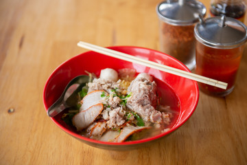Pork Tom Yum Noodle in Red Bowl, Spoon and Chopsticks