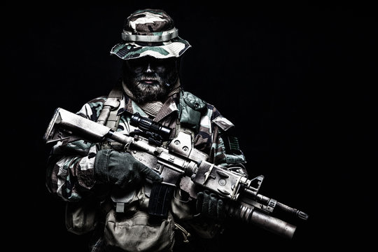 Commando soldier in battle ammunition, armed rifle