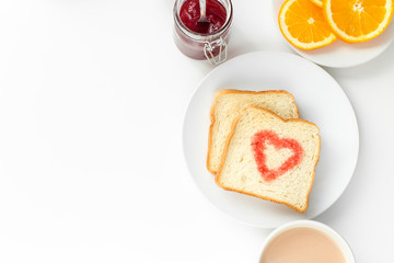 Breakfast with cup of tea, slice orange, toast heart of berry jam