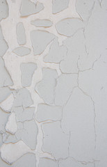 Cracked white wall paint peeling off