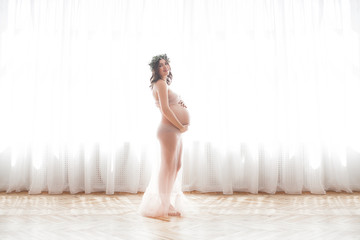 Beautiful pregnant woman on neutral background. Expectant closeup picture. Future mother portrait on pastel background.