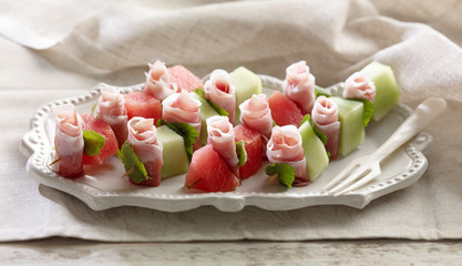Parma Ham and Melon Starter on white plate and cloth background