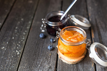 jars of blueberry and tangerine jam on a old wooden background