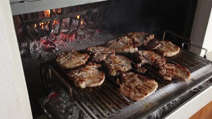 Steaming chops cooked on the embers in a fireplace, Italy