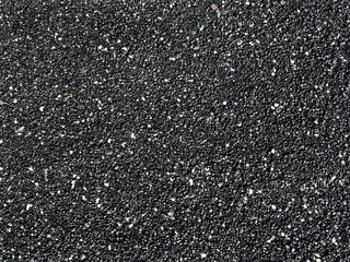Surface small round crushed stone. Black sand beach. Abstract background