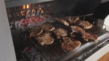 Chops that are turned while cooking on the grill in a fireplace, Italy