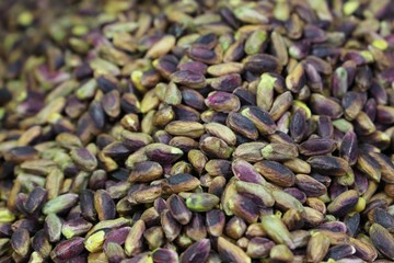 Pistachios in white porcelain bowls. Roasted pistachio seeds in shells and shelled