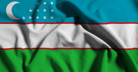 Obraz premium National flag of Uzbekistan on a waving cotton texture background