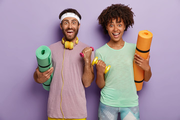 Workout, fitness and sport concept. Cheerful mixed race couple have workout, raise arms with...