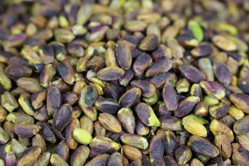 Pistachios in white porcelain bowls. Roasted pistachio seeds in shells and shelled