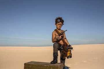 Post-apocalyptic boy outdoors in desert.