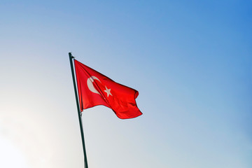 waving Turkish flag against sky and rising sun, copy space
