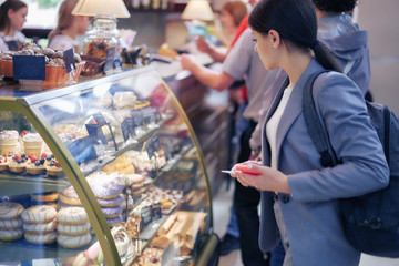 student chooses coffee cakes in a shop window