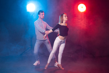 Social dance, kizomba, salsa and semba concept - young beautiful couple dancing bachata or salsa in the dark