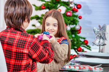 Young brother and sister at home for Christmas. Happy family in holiday season