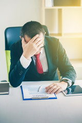 Businessmen feel headaches while working in the office.