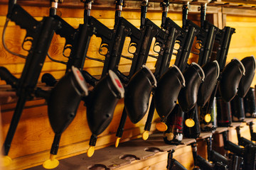paintball guns hanging on wood background