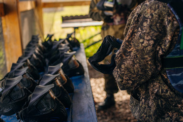 The player chooses Protective black paintball helmets lie on a wooden shelf ready for a new game, dry the helmet outside after washing, selective focus in the foreground