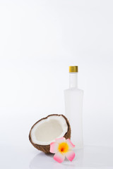 Coconut oil concept. Coconut with tall bottle isolated on white background.