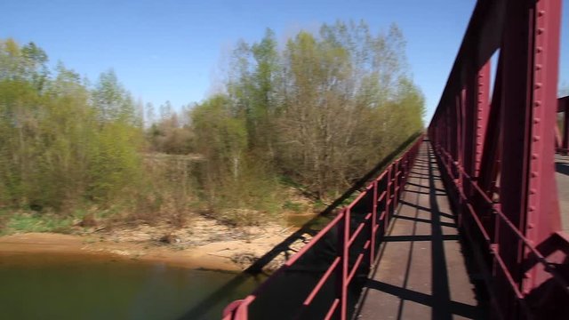  Panoramic of the river to the old iron bridge through which a truck and railway bridge pass in the background 