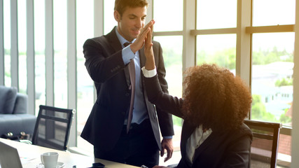 African and Hispanic colleague high five closing deal