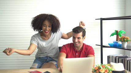 Happy Multi ethnic couple looking for Summer deal on internet