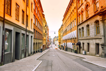 Fototapeta na wymiar 8 July 2019 Stockholm, Sweden. Colourful buildings down town with people walking around in Stockholm